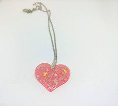 Your choice of ONE fun heart necklace! Unless you choose more than 1! Each necklace is clear resin with fine coordinating glitter with silver holographic stars, cute! PINK: Clear Resin, Fine Pink Glitter, Holographic Stars BLUE: Clear Resin, Fine Blue Glitter, Holographic Stars YELLOW/GOLD: Way more gold than yellow! Cleaer Resin, yellow/gold fine glitter, Holographic Stars Clear: Clear Resin, Silver Glitter, Holographic Stars Just a heads up that you can kind of see through the Clear option the Silver Heart Necklace With Star Charm, Pink Resin Party Necklaces, Heart-shaped Necklace With Star Charm As A Gift, Silver Glitter Necklace For Gift, Silver Glitter Jewelry For Valentine's Day, Cute Glitter Jewelry Gift, Valentine's Day Silver Glitter Jewelry, Stars Yellow, Silver Holographic