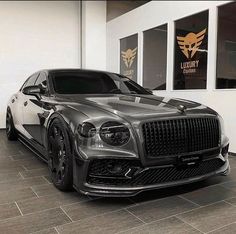 a black and silver car parked in front of a building