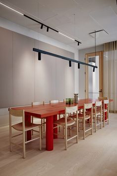 a long wooden table with chairs around it in an empty room next to sliding glass doors