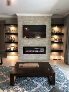 a living room with a fireplace and television mounted on the wall above it's mantle