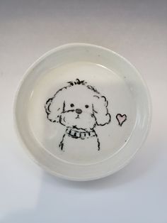 a small white bowl with a drawing of a dog on it