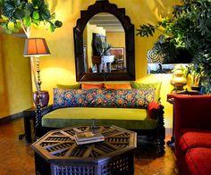 a living room with yellow walls and colorful furniture