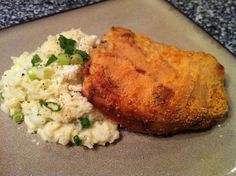 a piece of chicken and mashed potatoes on a plate with parmesan dip crusted pork chops