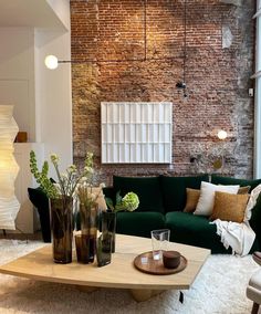 a living room filled with furniture and a brick wall behind the couches in front of it