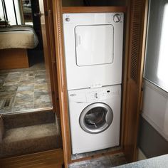 a washer and dryer in a small room with stairs leading up to the bed