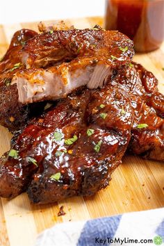 two pieces of meat sitting on top of a cutting board next to a jar of ketchup