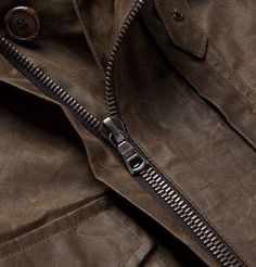 a close up view of a leather jacket with zippers and buttons on the collar