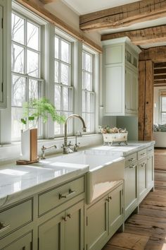 a large kitchen with green cabinets and white counter tops, along with wooden flooring