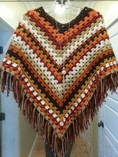 a crocheted shawl hanging on a door way