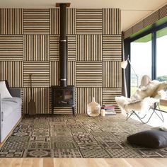 a living room with a couch, chair and wood burning stove in the wall behind it