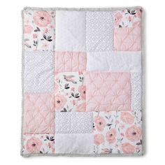 a pink and white quilt with flowers on it