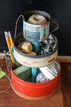 an old tin can is filled with assorted crafting supplies and other things to make crafts