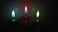 three lit candles sitting next to each other on a table