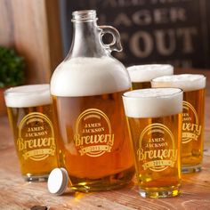 four beer glasses and a jug sitting on a table