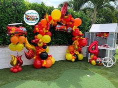 balloons are arranged in the shape of an animal and firetruck on display at a birthday party