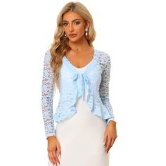 Opt for a decadent cover-up for your special occasions with this lace shrug. This stretchy lace cardigan offers the perfect balance to longer layers in a waist-defining cut with a tie front. Constructed in a classic shrug silhouette, this charming piece benefits from an open neck and elegant long sleeves with ruffles. Intricate design details include a satin binding around the front and hem and a floral lace design. Paired with a sleeveless dress, spaghetti strap, tank top, or simple off-shoulde Fitted Lace Cardigan With Crochet Lace, Fitted Lace Cardigan With Crochet Details, Long Sleeve Lace Cardigan With Lace Patchwork, Long Sleeve Lace Shrug With Lace Trim, Fitted Lace Cardigan With Open Front, Fitted Lace Open Front Cardigan, Fitted Lace Cardigan For Party, Spring Party Lace Cardigan, Longer Layers