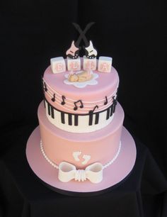 a three tiered cake with musical notes on the top and baby's name