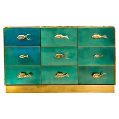 a green and gold dresser with fish on the front, one side is painted blue