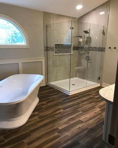 a bathroom with a tub, sink and shower stall in the middle of the room