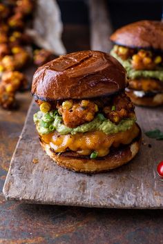 a chicken sandwich with guacamole and corn on it sitting on a cutting board