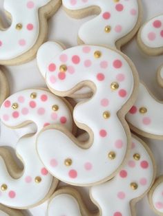 decorated cookies with pink and white polka dots are arranged in the shape of an s