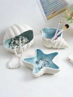 three star shaped dishes with pearls and beads in them sitting on a table next to a cell phone