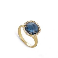 A luxurious London blue topaz cut by master artisans, cradled by four prongs, nestles in an18K yellow gold frame embellished with dazzling diamonds in this radiant ring from Marco Bicego's Jaipur Color collection. The golden band has been hand-hammered and hand-engraved with the Bulino technique, a signature of the Italian designer. This colorful Marco Bicego ring has color and character! Topaz Diamond Ring, Radiant Ring, Marco Bicego, Circle Diamond, Circle Ring, Italian Designer, London Blue Topaz, London Blue, Color Collection