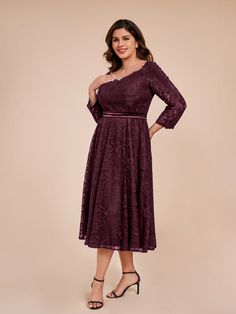 a woman in a purple dress posing for the camera