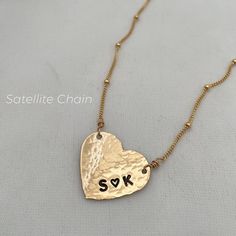 Love is always in style with our Hammered Personalized Heart Necklace. This customer favorite is ideal for initials, a date, a nickname, or a short word. The charming, vintage-style link chain is the perfect finishing touch and adds a romantic vibe. This gorgeous piece is perfect for everyday wear. The heart charm is approx. 3/4 inch. It can be personalized with up to 5 characters. Popular symbols for personalization are &, +,❤, * (you can use an asterisk * to symbolize the heart symbol). Example: B * A, B & A, B + A, B ❤ A 14kt gold fill or sterling silver custom heart charm measures 3/4in 14kt gold fill or sterling silver chain Our model wears a Hammered Personalized Heart Necklace at 18 inches and our Radiant Lock Necklace in silver at 16 inches. Elegant Brass Necklaces For Valentine's Day, Brass Heart Charm Necklace For Wedding, Brass Heart Pendant Jewelry For Anniversary, Brass Heart Pendant Jewelry For Wedding, Brass Heart Pendant Wedding Jewelry, Rose Gold Heart Necklace With Adjustable Chain For Wedding, Double Heart Initials Jewelry For Anniversary Gift, Double Heart Initials Jewelry For Anniversary, Initials Double Heart Jewelry For Anniversary