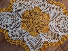 two yellow and white crocheted doily on wooden floor