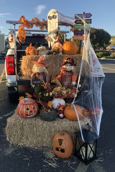 a truck with pumpkins and decorations in the back