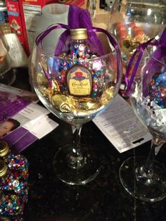 two wine glasses filled with candy and confetti on top of a black table