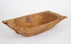 a wooden bowl sitting on top of a white table