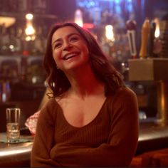 a woman sitting at a bar smiling for the camera