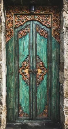 an old wooden door with ornate carvings on it's sides and the top panel is painted green