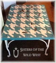 a table that has some kind of checkerboard design on it, with the words sisters of the wild west