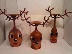 three brown vases with faces painted on them sitting next to each other in front of a white background