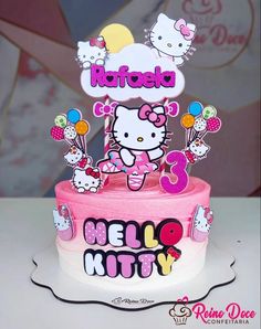 a hello kitty birthday cake with balloons on top