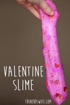 a pink slime is held up in the air by someone's hand with text overlay that reads, valentine slime