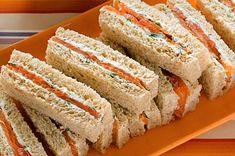 several sandwiches are arranged on an orange plate