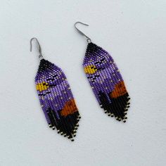 the beaded earrings are decorated with purple and orange beads