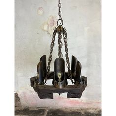 an old chandelier hanging from a chain with bells on the front and back