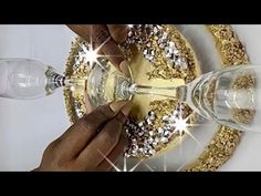 two people are toasting wine glasses with gold and silver decorations on the rims