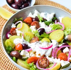 a salad with olives, tomatoes, cucumbers and feta cheese in a bowl