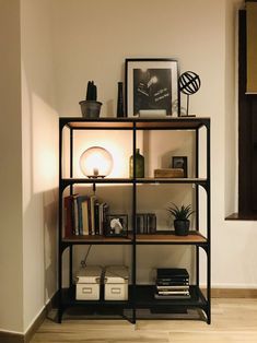 a bookshelf with many items on top of it in front of a wall