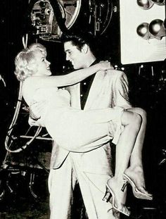 a man and woman dance together in front of an old time radio set with balloons