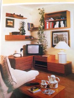 an old photo of a living room with coffee table and shelves on the wall above it