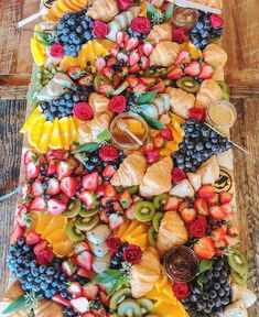 an assortment of fruits and pastries are arranged on a platter to be served