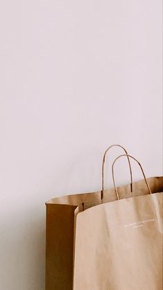 a brown paper bag sitting on top of a wooden table next to a white wall