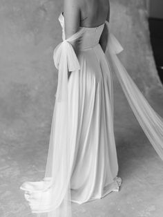 the back of a woman's dress, with long veil draped over her shoulders